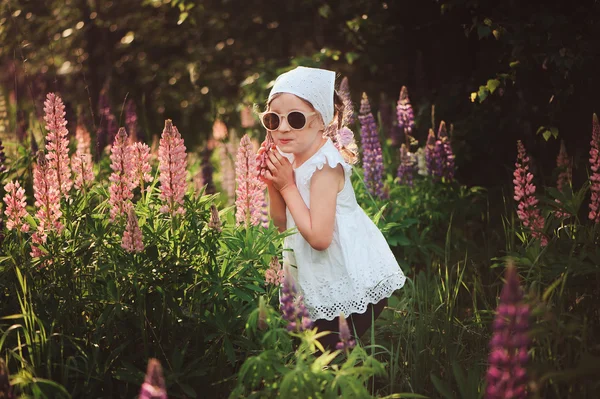 Child girl on flowering lupin field — Stock Photo, Image
