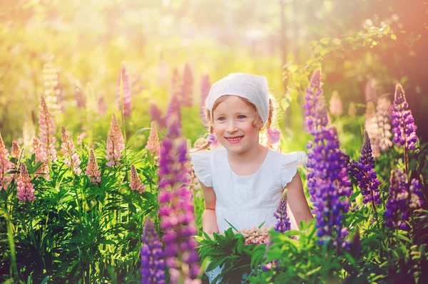Dítě dívka na kvetoucí lupiny pole — Stock fotografie
