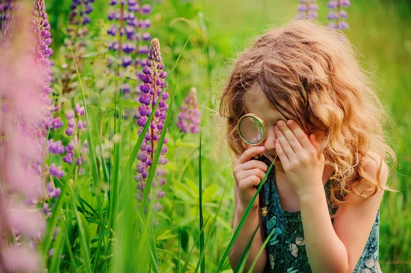 Child girl exploring nature with loupe, learning on summer vacation in forest — Zdjęcie stockowe