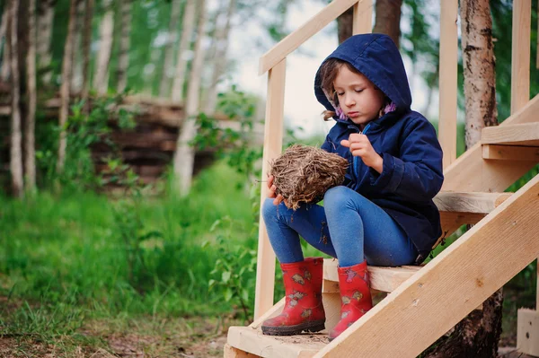 Bambina che gioca con nido d'uccello su scale di legno in estate — Foto Stock