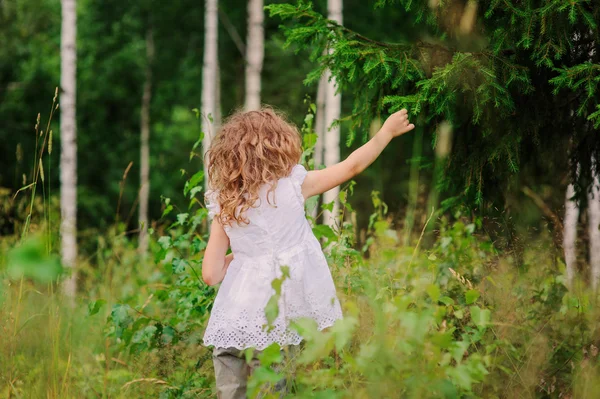 Счастливая девочка в летнем лесу — стоковое фото