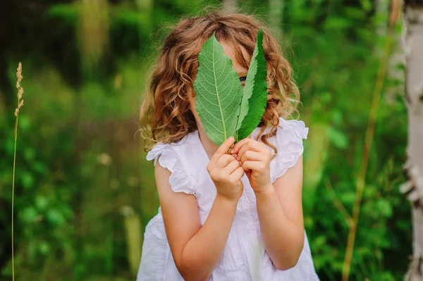 Cute child girl with green leaves — Stock Photo, Image