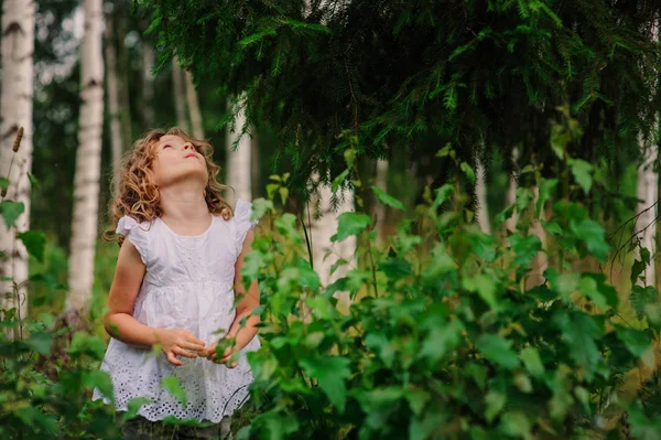 Счастливая девочка в летнем лесу — стоковое фото