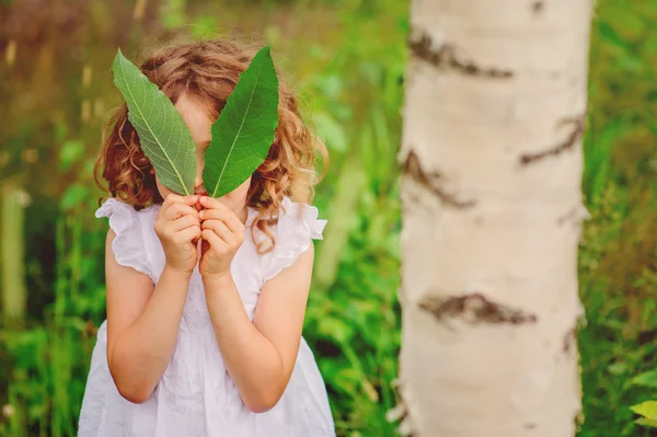 Linda niña con hojas verdes — Foto de Stock