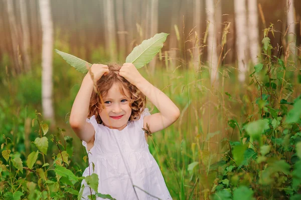 Roztomilé dítě dívka se zelenými listy — Stock fotografie