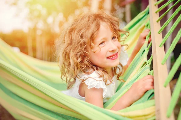 Happy child girl relaxing in hammock, cozy warm summer scene — Stock Photo, Image