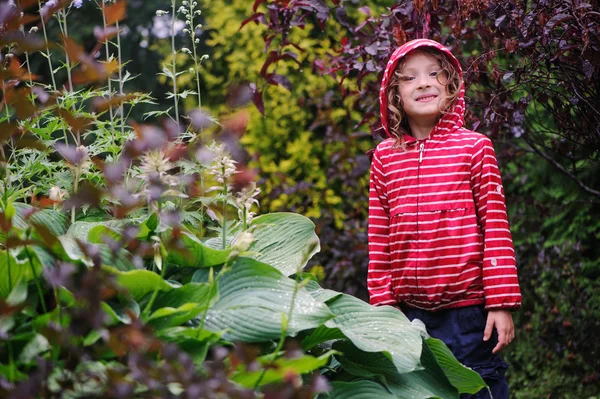 Bambino felice ragazza sulla passeggiata in giardino piovoso — Foto Stock