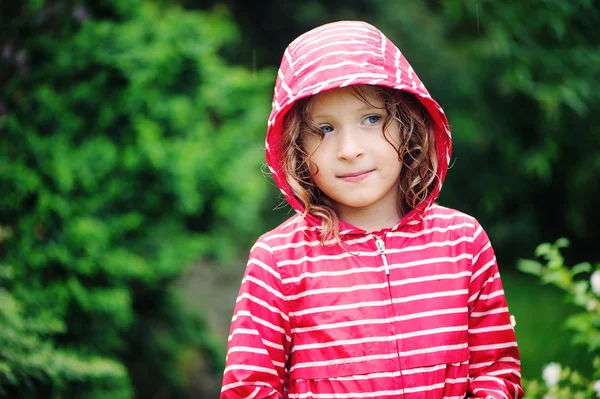 Happy child girl on the walk in rainy garden — Stock Photo, Image