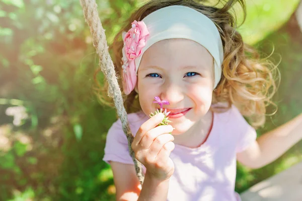 Niña feliz en columpio en el jardín — Foto de Stock