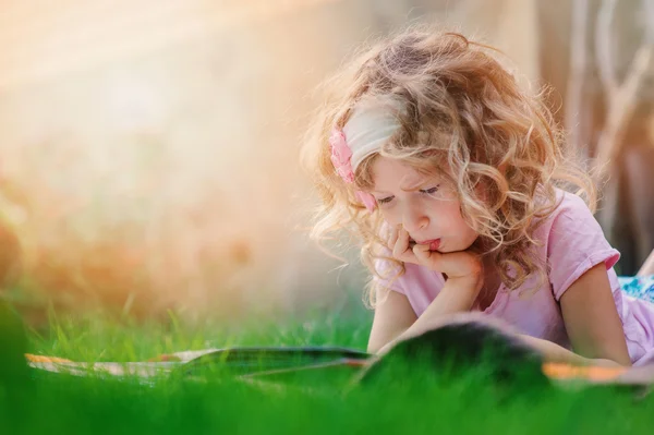 Zadumany ładny dziecko dziewczynka czytanie książki — Zdjęcie stockowe