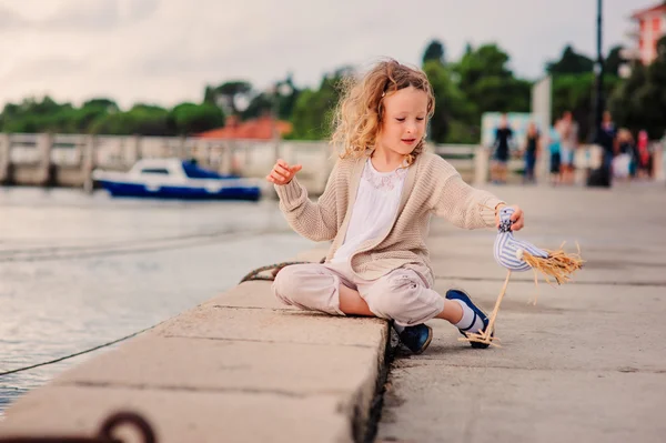 Curly child girl playing on sea side — Stock Photo, Image