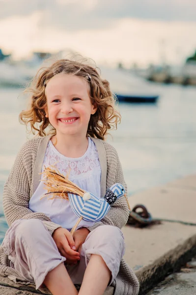 Kręcone dziecko dziewczynka grający na stronie morza — Zdjęcie stockowe