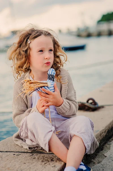 Gekrulde kind meisje spelen op zee-zijde — Stockfoto