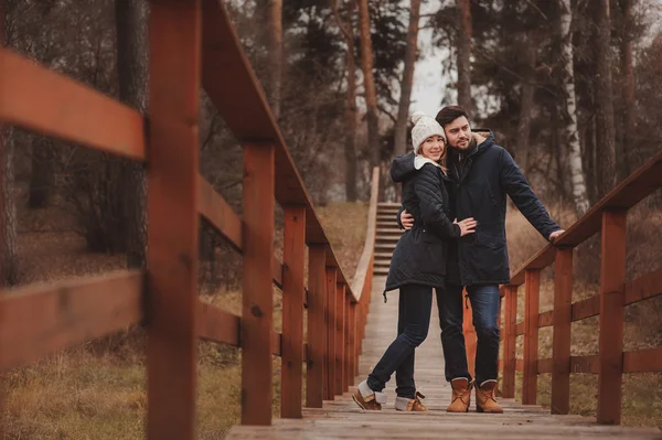 Amando jovem casal feliz juntos ao ar livre em acolhedor passeio quente na floresta — Fotografia de Stock