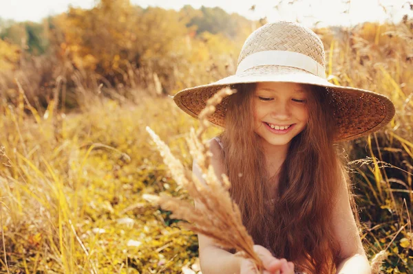 Feliz niña en paja divertirse al aire libre en verano campo soleado — Foto de Stock