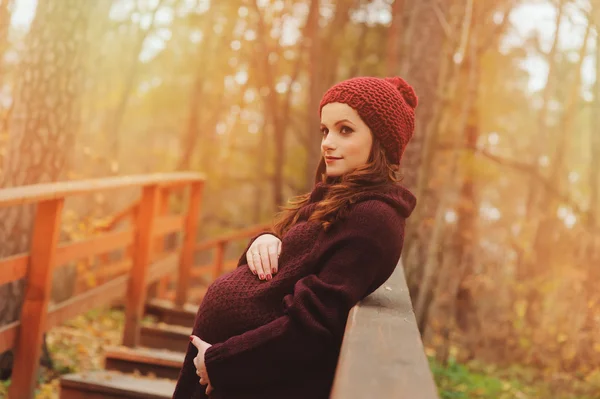 Beautiful pregnant woman in cozy warm outfit walking in autumn forest — Stock Photo, Image