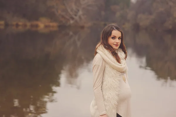 Feliz hermosa mujer embarazada en acogedor paseo al aire libre en el lado del río, suave tono cálido —  Fotos de Stock