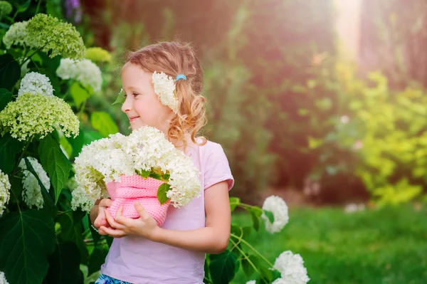 Ortanca kokulu sıcak yaz bahçesinde açık oynayan kız mutlu çocuk — Stok fotoğraf