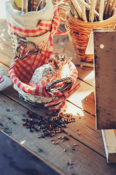 Alimentador de pássaros com sementes na mesa de madeira na casa de campo aconchegante, vintage tonificado, foco seletivo — Fotografia de Stock