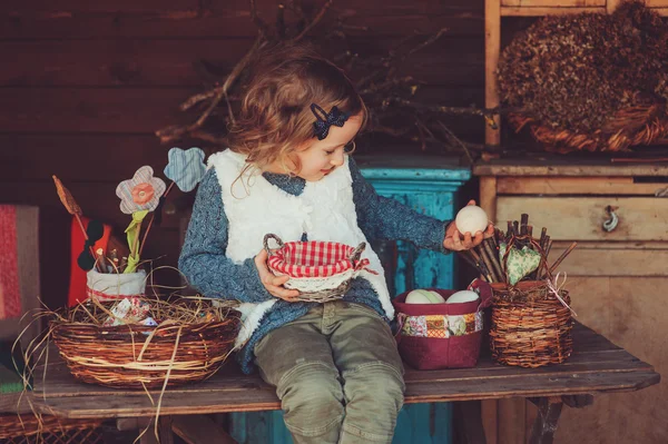 Child girl playing with easter eggs and handmade decorations in cozy country house — Stock Photo, Image