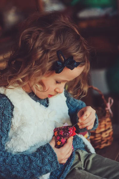 Child girl playing with easter eggs and handmade decorations in cozy country house — Stock fotografie