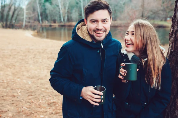 Lifestyle capture of happy couple drinking hot tea outdoor on cozy warm walk in forest — Stock Photo, Image