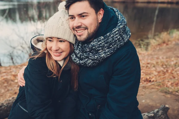 Happy couple in warm knitted hat and scarf walking outdoor in autumn forest, cozy mood — 图库照片