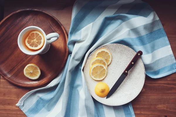 Tè caldo con fette di limone sul tavolo di legno, vista dall'alto, accogliente ambiente domestico — Foto Stock