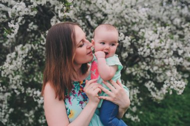 mutlu sevgi dolu aile ile çiçeklenme içinde bebek kızı bahar bahçe. Küçük kız babası. Birlikte vakit açık