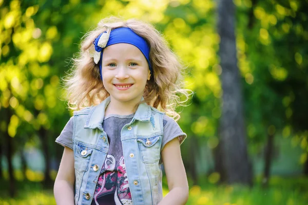 Heureux enfant fille jouer sur coloré champ de printemps. Pissenlits en fleurs sur fond, activités de plein air saisonnières. Humeur chaleureuse confortable . — Photo