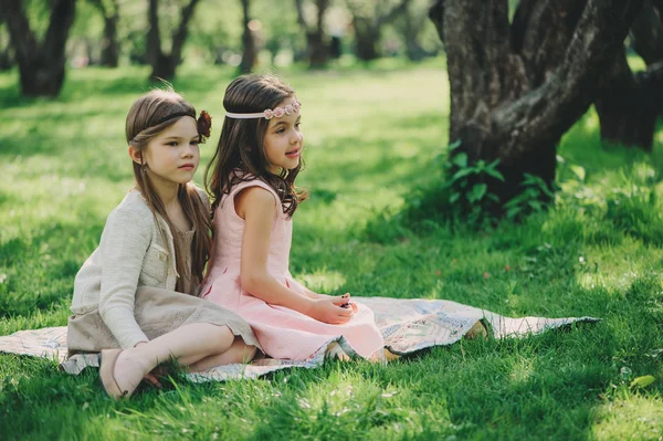 Joyeuses petites amies jouant ensemble au parc printanier. Soeurs habillées s'amusant en plein air sur la promenade chaleureuse et confortable. Concept d'amitié . — Photo