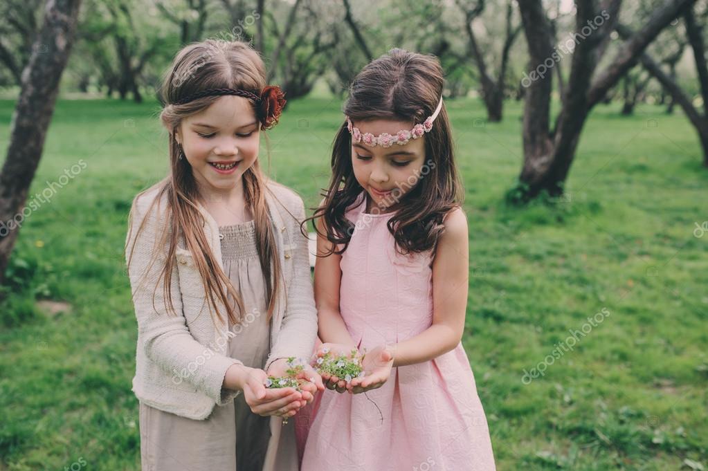 Stock photography ▻ Two happy little girlfriends picking flowers in spring ...