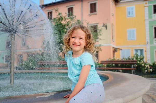Child girl relaxing at fountain in Izola (Isola) city in Slovenia. Traveling in Europe on summer vacation — Zdjęcie stockowe