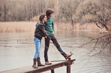 mutlu genç sevgi dolu çift kırsal üzerinde erken Bahar yağmurlu günde yürüyüş.