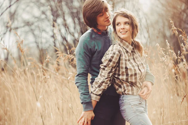 Joven feliz amante pareja caminando en el campo, ambiente acogedor, escena rural — Foto de Stock