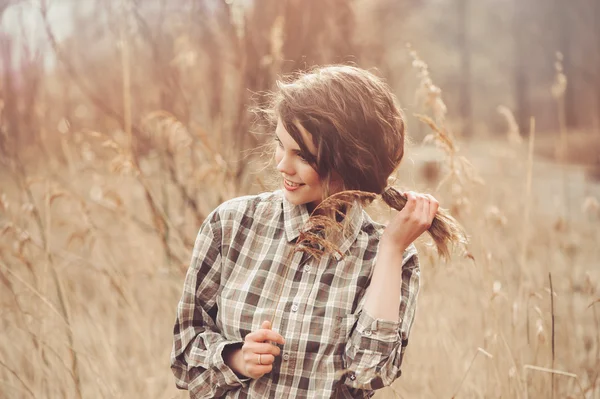 Adorable joven mujer en camisa a cuadros en acogedor país caminar en el campo —  Fotos de Stock
