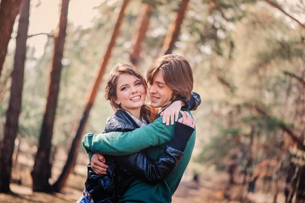 Glückliches Liebespaar, das Wälzer zusammen im Wald verbringt. junger Freund und Freundin Umarmungen im Freien. — Stockfoto