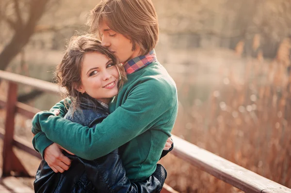 Joven pareja amorosa abraza al aire libre a principios de primavera. La familia pasa tiempo juntos. Acogedora escena rural . — Foto de Stock