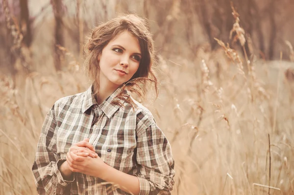 Joven mujer feliz en camisa a cuadros en el paseo por el campo. Acogedora escena rural —  Fotos de Stock