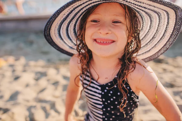 Niño feliz en traje de baño relajarse en la playa de verano y broncearse un poco. Clima cálido, ambiente acogedor. Viajar en vacaciones de verano . — Foto de Stock