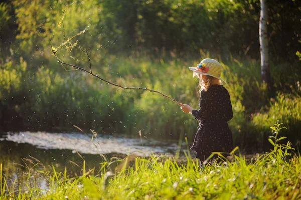 Dreamy child girl on summer walk on riverside. Cozy rural scene. Outdoor activities on summer vacations. — ストック写真