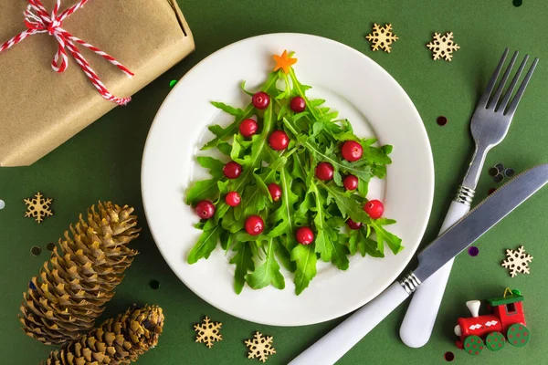 Masadaki beyaz tabakta Noel ağacı salatası. Düz yatıyordu