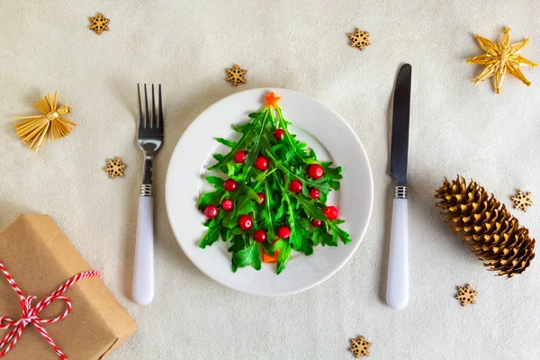 Masadaki beyaz tabakta Noel ağacı salatası. Düz yatıyordu