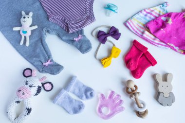 Beyaz arka planda bebek aksesuarları olan bir kompozisyon. Kızlar tarafsız tema. düz ve üst görünüm