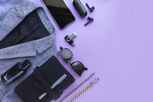 Mens accessories, notebook, airpods, sunglasses, car model on lilac background. Top view, flat lay.