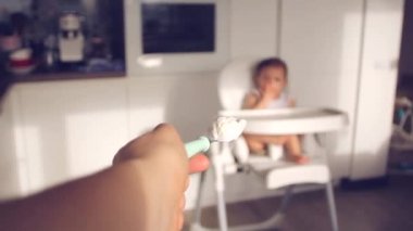 Anneler Eli, evdeki mutfakta bebeğine mama veriyor. Yaratıcı bakış açısı