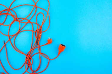 Mavi arka planda turuncu elektrik kablosu. Boşluğu kopyala