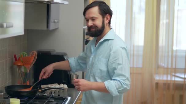 Άνθρωπος στην κουζίνα μαγείρεμα πιάτο και χρησιμοποιώντας ψηφιακή ταμπλέτα — Αρχείο Βίντεο