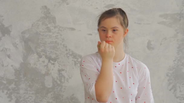 Aantrekkelijk gelukkig tiener meisje met Down Syndroom schildert lippen met lippenstift — Stockvideo