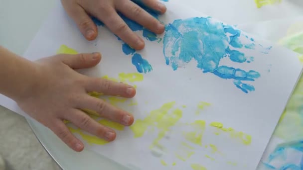 Pintura con pintura amarilla y azul en las manos — Vídeos de Stock